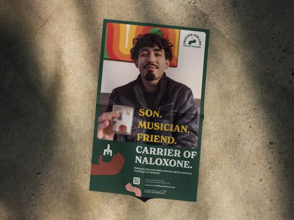 Image of a poster with a male with dark curly hair and dark facial hair