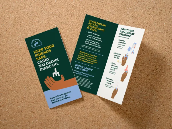 Brochure with a dark background and a hand holding naloxone