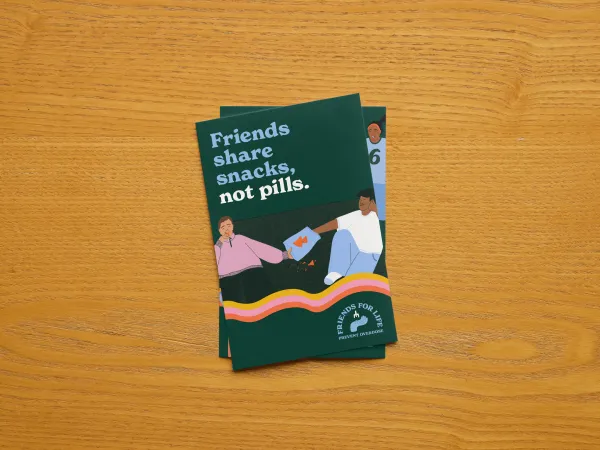 Postcard with dark background and two people sharing a snack