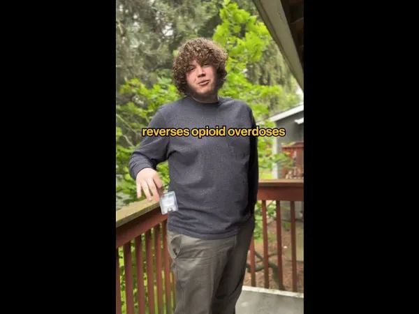 A person holding naloxone nasal spray and explaining what it is.